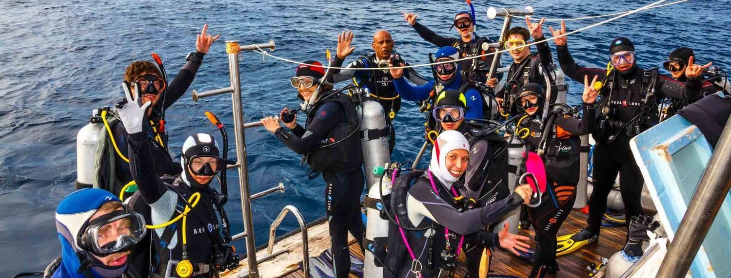 Сдача открытой воды в поездке с клубом Морские Ангелы дайверы готовятся к погружению в открытую в воду в Египте